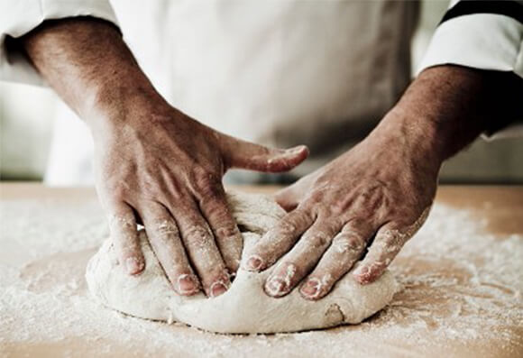 A chef kneading pizza dough 11149417